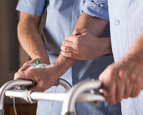 Nurse helping an elderly man to walk